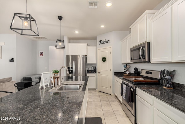 kitchen with white cabinets, decorative light fixtures, sink, and appliances with stainless steel finishes