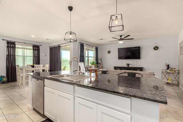 kitchen featuring dishwasher, a kitchen island with sink, sink, hanging light fixtures, and white cabinetry