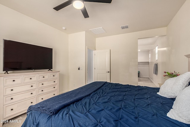 bedroom with light carpet, ensuite bathroom, and ceiling fan