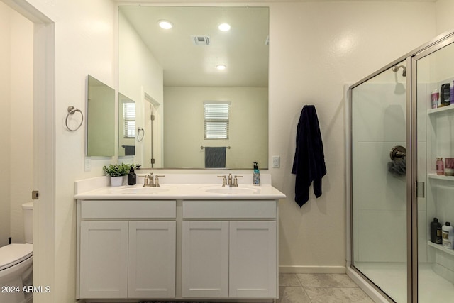 bathroom with tile patterned flooring, vanity, toilet, and walk in shower