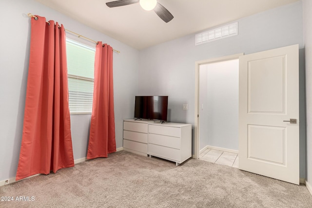 unfurnished bedroom featuring light colored carpet and ceiling fan