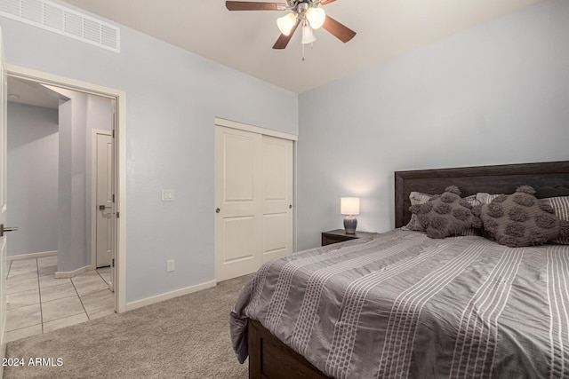 carpeted bedroom with ceiling fan and a closet