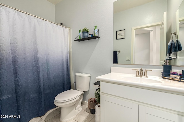 bathroom featuring curtained shower, tile patterned flooring, vanity, and toilet