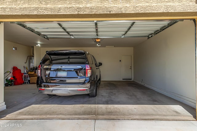 garage featuring water heater and a garage door opener