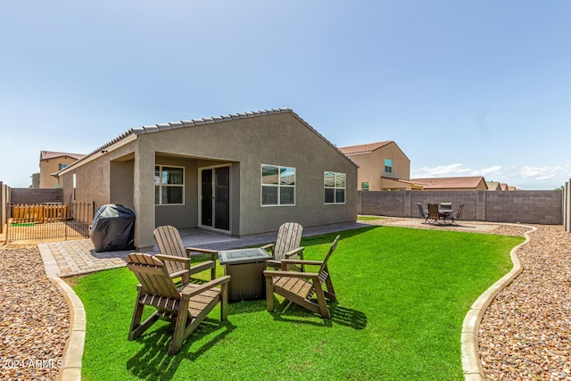 back of property with a yard and a patio