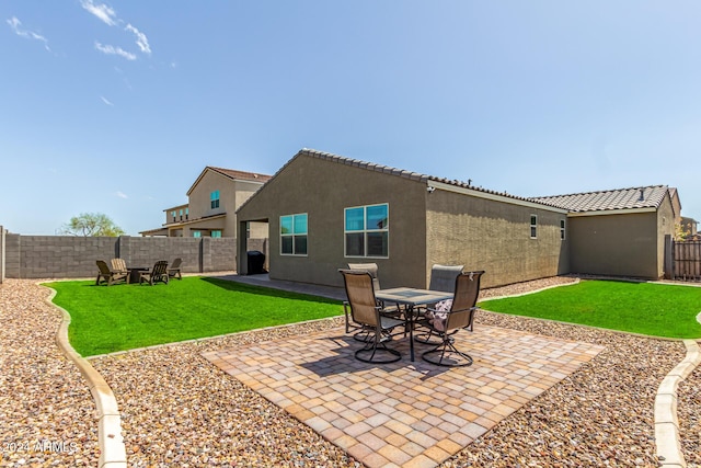 rear view of property featuring a yard and a patio