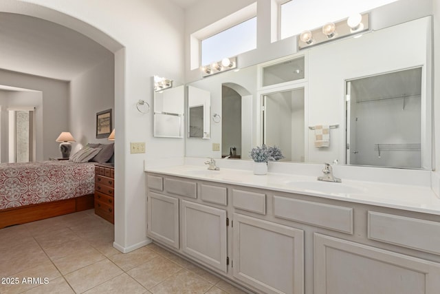 ensuite bathroom featuring tile patterned floors, double vanity, a sink, and ensuite bathroom