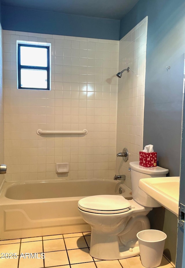 bathroom featuring tile patterned floors, tiled shower / bath combo, and toilet