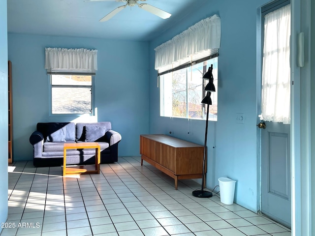 living area with ceiling fan and light tile patterned floors