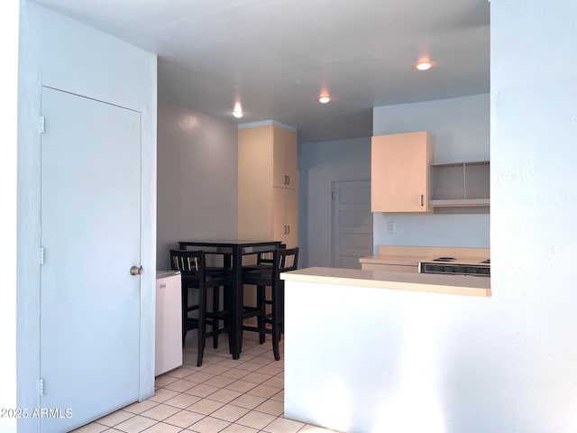 kitchen with light tile patterned flooring and kitchen peninsula