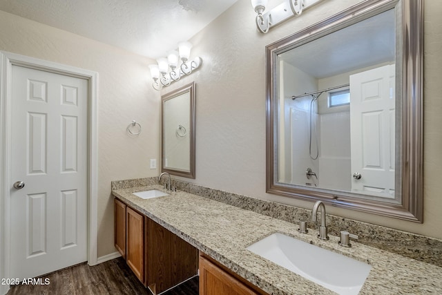 bathroom featuring bathtub / shower combination, hardwood / wood-style floors, vanity, and a textured ceiling