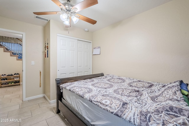 tiled bedroom with ceiling fan and a closet