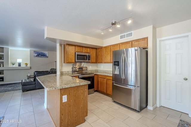 kitchen featuring light stone counters, kitchen peninsula, appliances with stainless steel finishes, and light tile patterned flooring