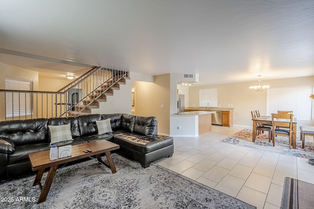 living room with sink, a chandelier, and light tile patterned floors