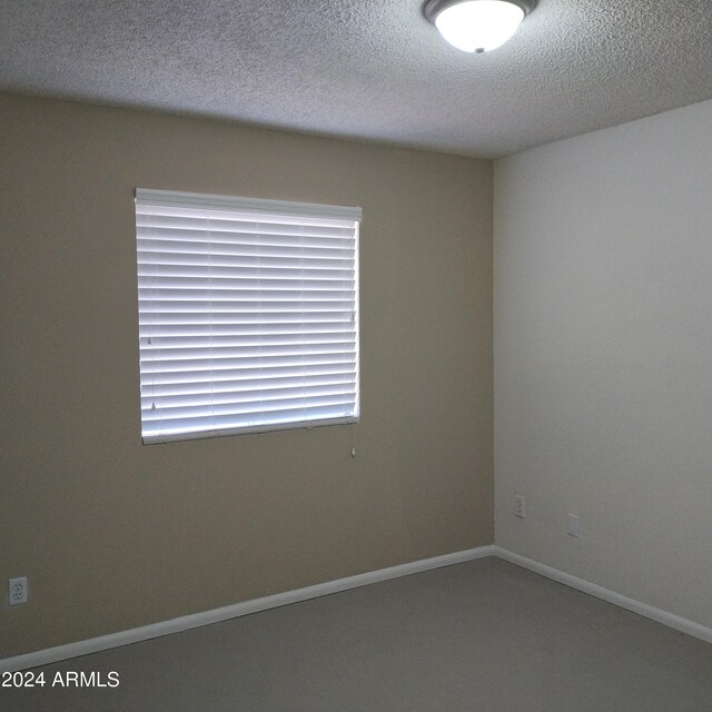 unfurnished room featuring a textured ceiling