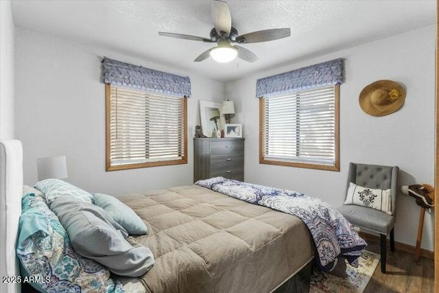 bedroom featuring ceiling fan, hardwood / wood-style floors, and a textured ceiling