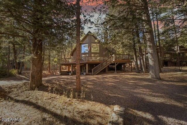 back house at dusk with a wooden deck