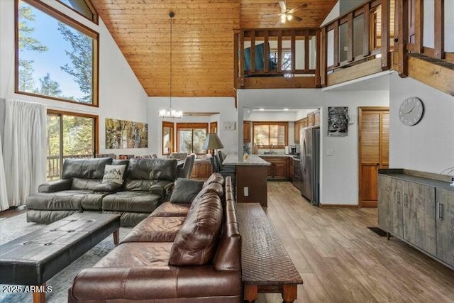 living room featuring high vaulted ceiling, a notable chandelier, wood ceiling, and light hardwood / wood-style floors