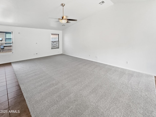 unfurnished living room featuring lofted ceiling, ceiling fan, tile patterned flooring, visible vents, and carpet