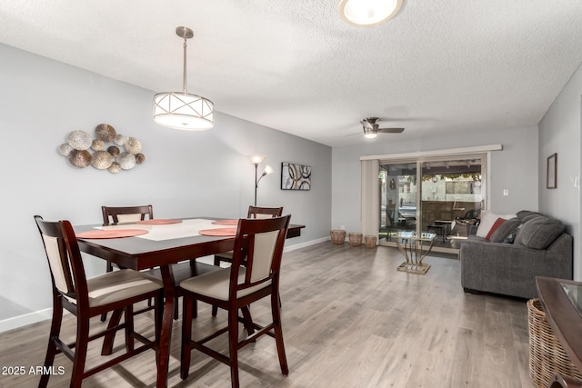 dining area featuring a textured ceiling, ceiling fan, and wood-type flooring