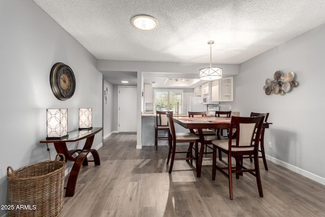 dining area featuring a textured ceiling and hardwood / wood-style floors