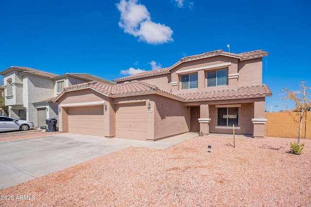 view of front of property featuring a garage, a tiled roof, concrete driveway, and stucco siding