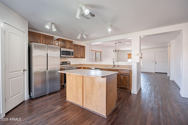 kitchen featuring light countertops, appliances with stainless steel finishes, dark wood-style flooring, and a sink