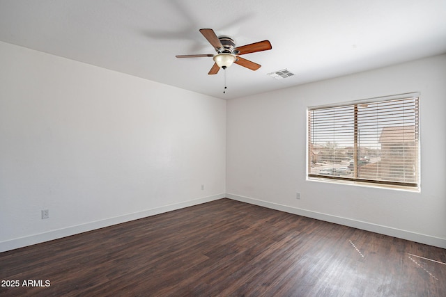 empty room with visible vents, dark wood finished floors, baseboards, and ceiling fan