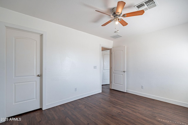 spare room with baseboards, visible vents, ceiling fan, and dark wood-type flooring