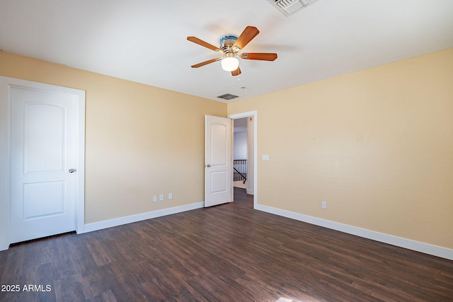 unfurnished bedroom featuring dark wood-style flooring, visible vents, and baseboards