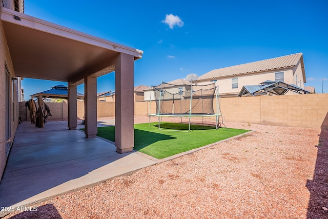 view of yard featuring a gazebo, a trampoline, a patio area, and a fenced backyard