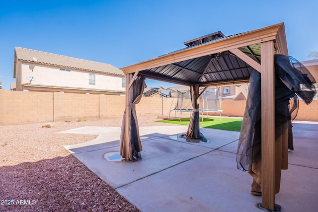 view of patio / terrace with a fenced backyard, a trampoline, cooling unit, and a gazebo