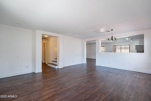 unfurnished living room with a chandelier, dark wood-style flooring, baseboards, and stairs