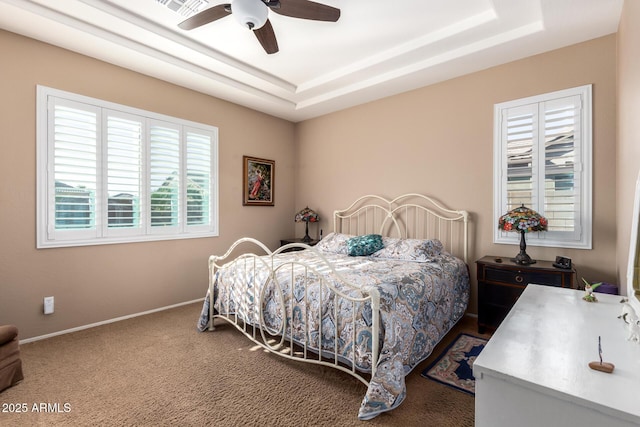 bedroom featuring ceiling fan, a raised ceiling, and carpet flooring