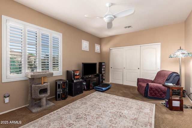 living area featuring ceiling fan and carpet floors