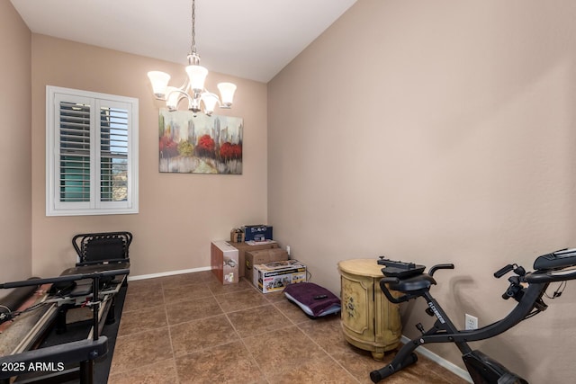 workout room with dark tile patterned flooring and a chandelier