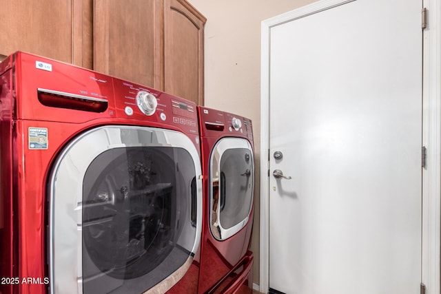 clothes washing area with independent washer and dryer and cabinets