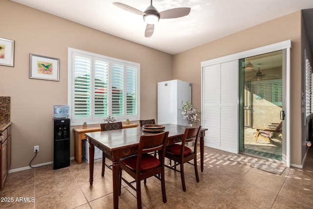 tiled dining room featuring ceiling fan