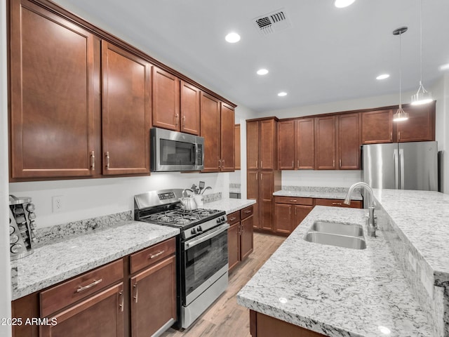 2882 W Presidio Dr, Flagstaff, AZ 86001 - kitchen featuring light wood finished floors, visible vents, hanging light fixtures, appliances with stainless steel finishes, and a sink