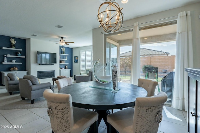 tiled dining area featuring ceiling fan with notable chandelier