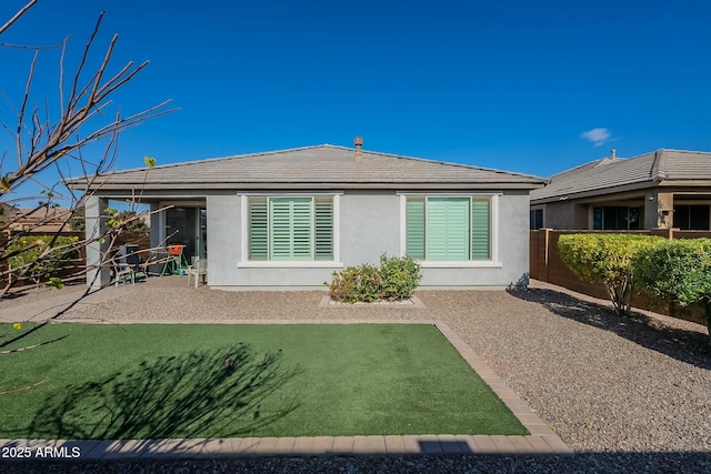 back of house with a lawn and a patio