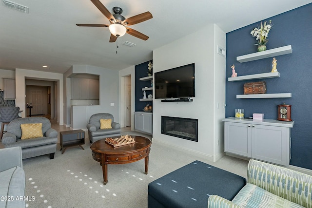 carpeted living room with built in features and ceiling fan