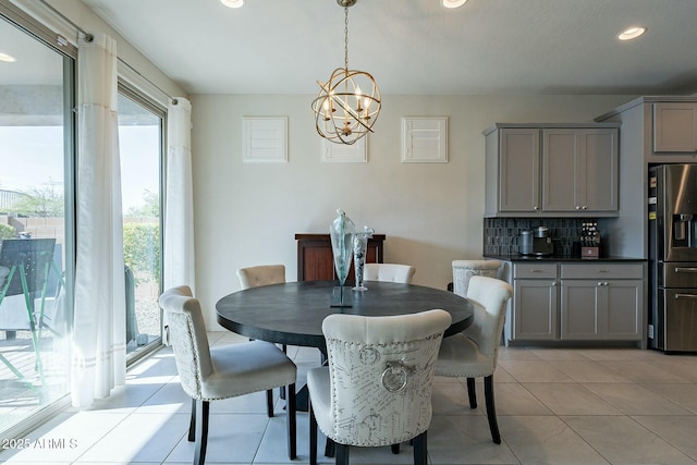 dining area with light tile patterned floors and a chandelier