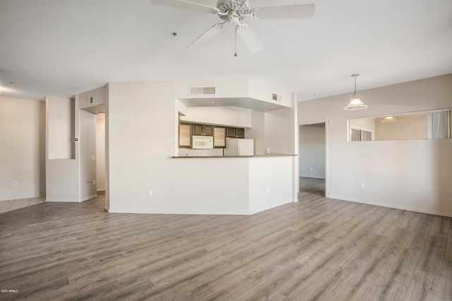 unfurnished living room featuring hardwood / wood-style floors and ceiling fan