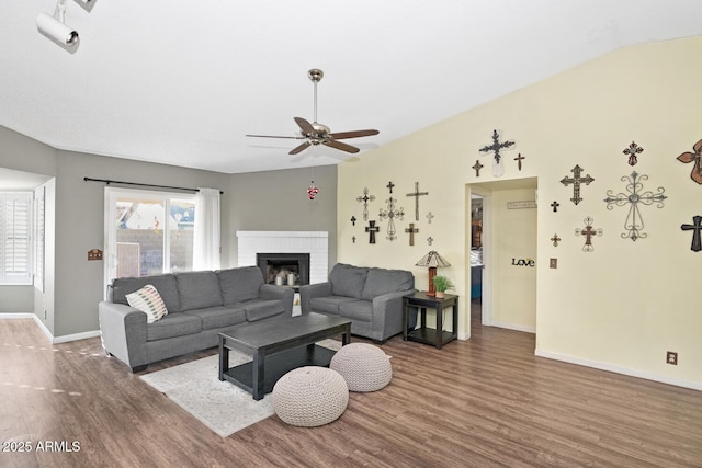 living room with a fireplace, dark hardwood / wood-style floors, and ceiling fan