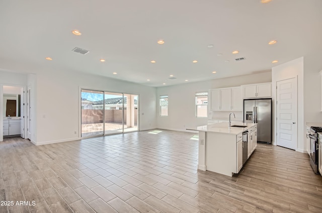 870 W Peralta Pass, Apache Junction, AZ 85120 - kitchen featuring stainless steel appliances, open floor plan, light countertops, baseboards, and white cabinetry