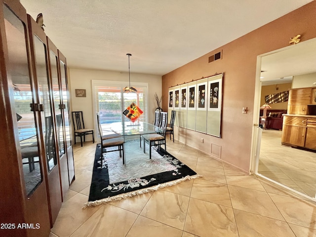 dining area featuring a textured ceiling and french doors