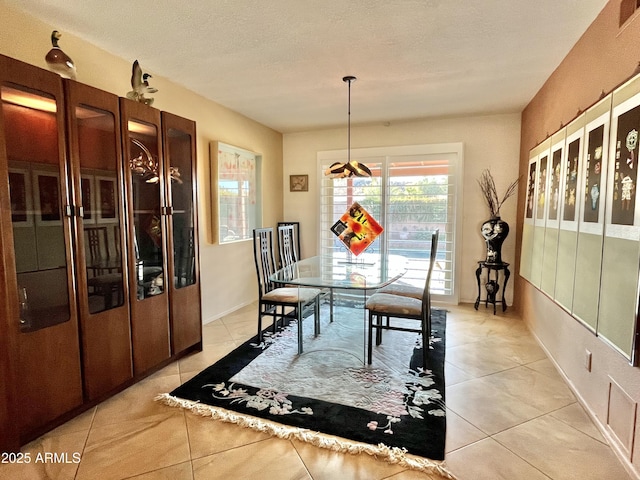 dining room with a textured ceiling and light tile patterned flooring