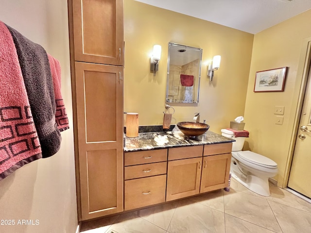 bathroom featuring toilet, vanity, walk in shower, and tile patterned flooring