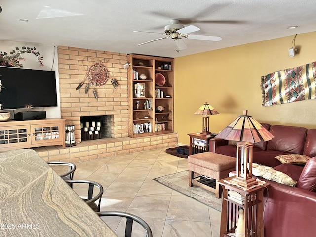 living room with ceiling fan, built in features, a brick fireplace, and a textured ceiling